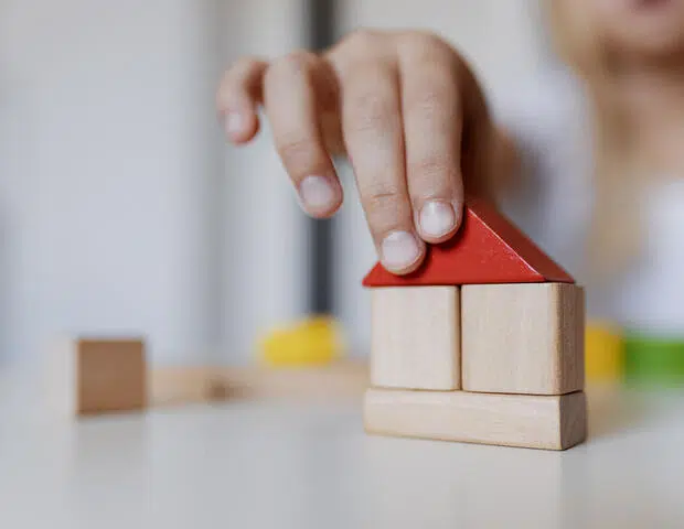 Child playing with colourful wooden toy building blocks image