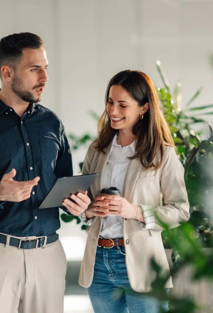 man holding tablet, talking to woman holding coffee image