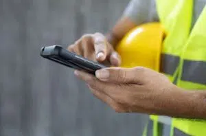 workman with hi-vis and hardhat on phone image