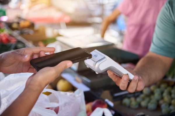 Person paying with phone in shop image